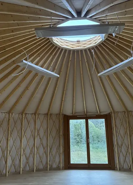Wnętrze jurty, gotowe: Widok na drewniany szkielet dachu i centralną kopułę.