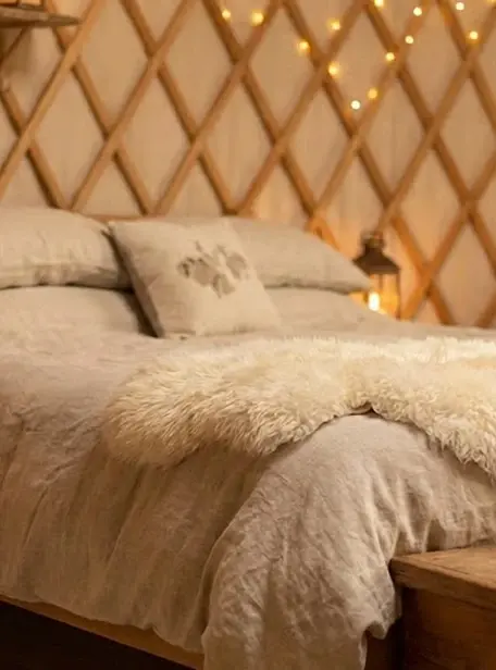 Przybliżenie na łóżko w jurcie z poduszkami i pledem