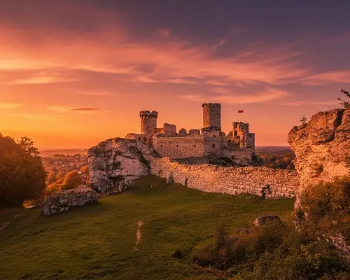 Zdjęcie zamku Ogrodziniec o złocistym zachodzie słońca w okolicy Jurajskich Jurt w Golczowicach